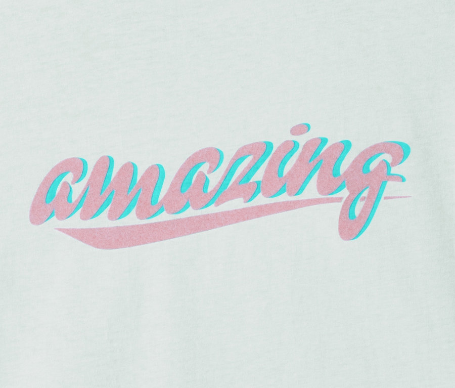 Hellgrünes T-Shirt aus Bio-Baumwolle mit rosafarbenem „amazing“-Schriftzug mit blauem Schatten.