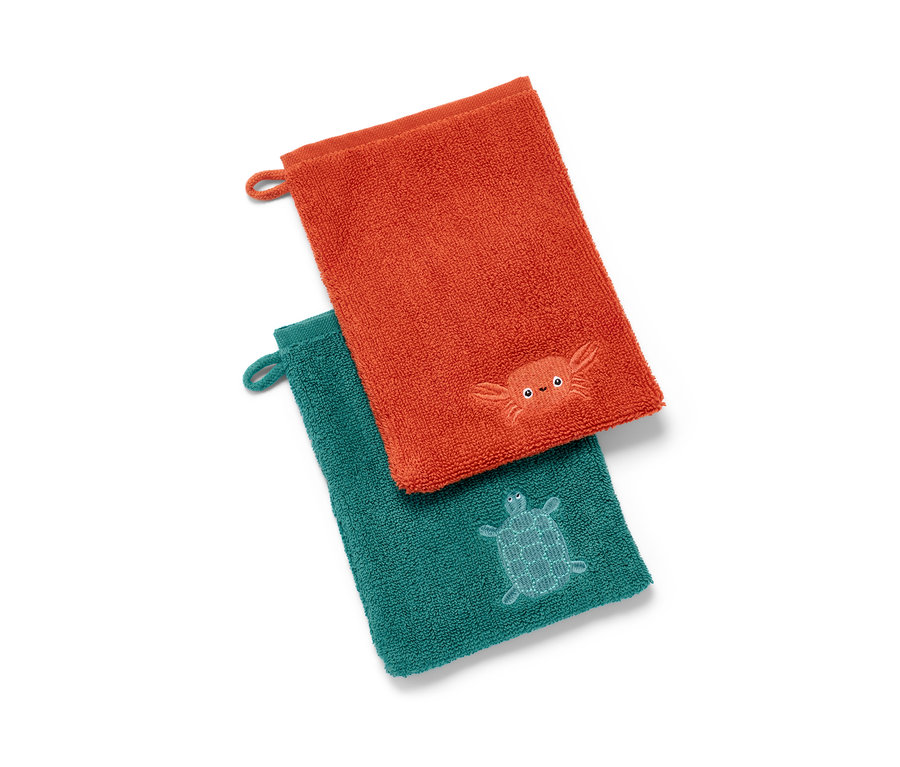 Zwei Waschlappen, ein orangefarbener mit einer Krabbe und ein grüner mit einer Schildkröte.