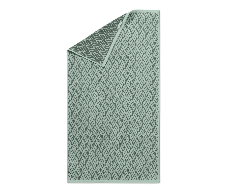 Ein grünes Jacquard-Badetuch mit Blattmuster.