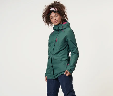 Frau trägt eine Ski-und-Snowboardjacke und Skihose.