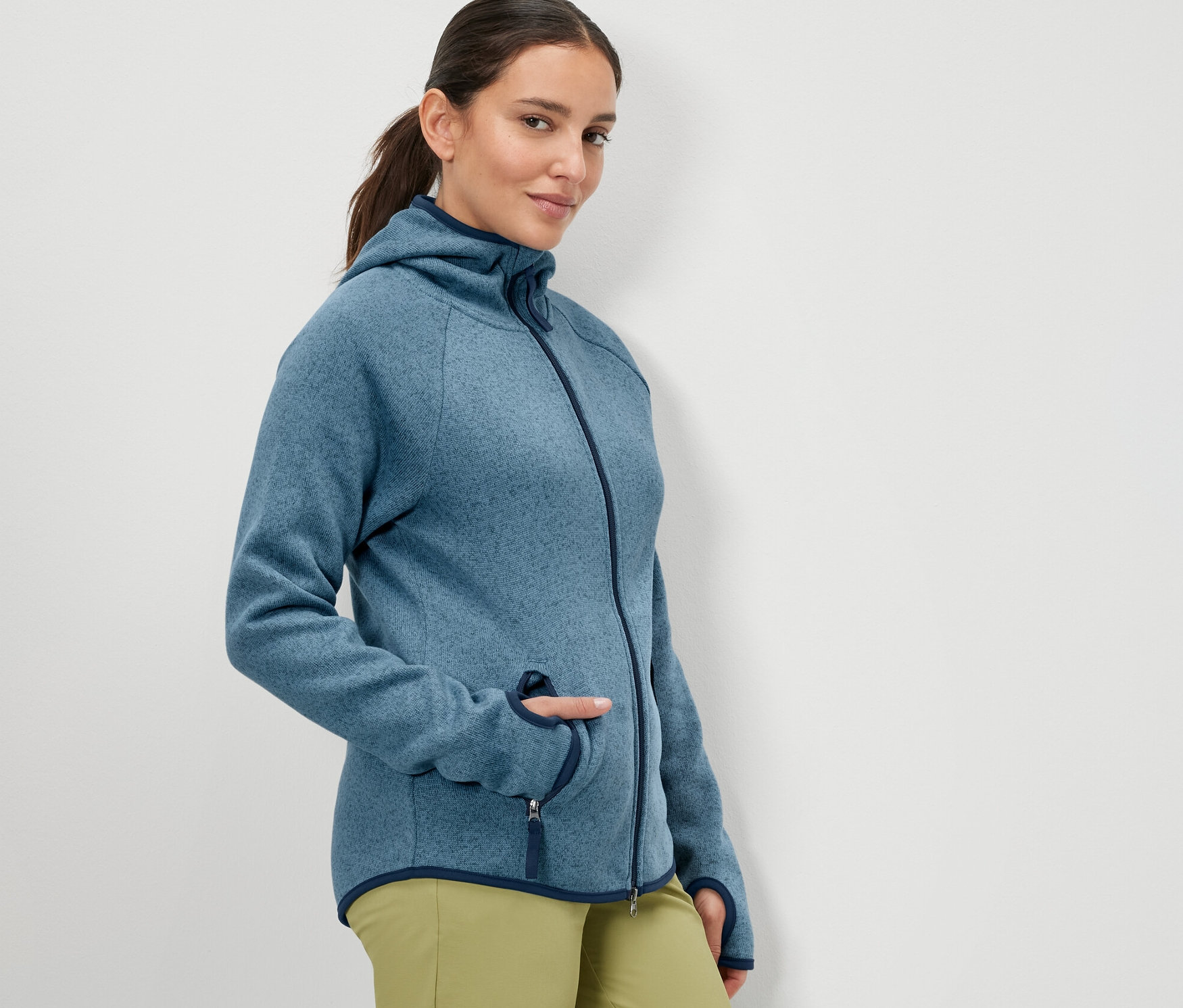 Frau posiert in dunkelblauer Strickfleece-Jacke.