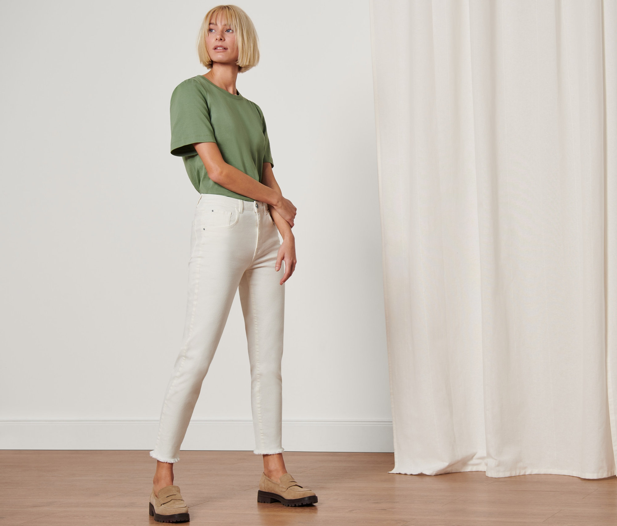 Frau posiert in Modern Denim »Fit Lilly« und grünem T-Shirt.