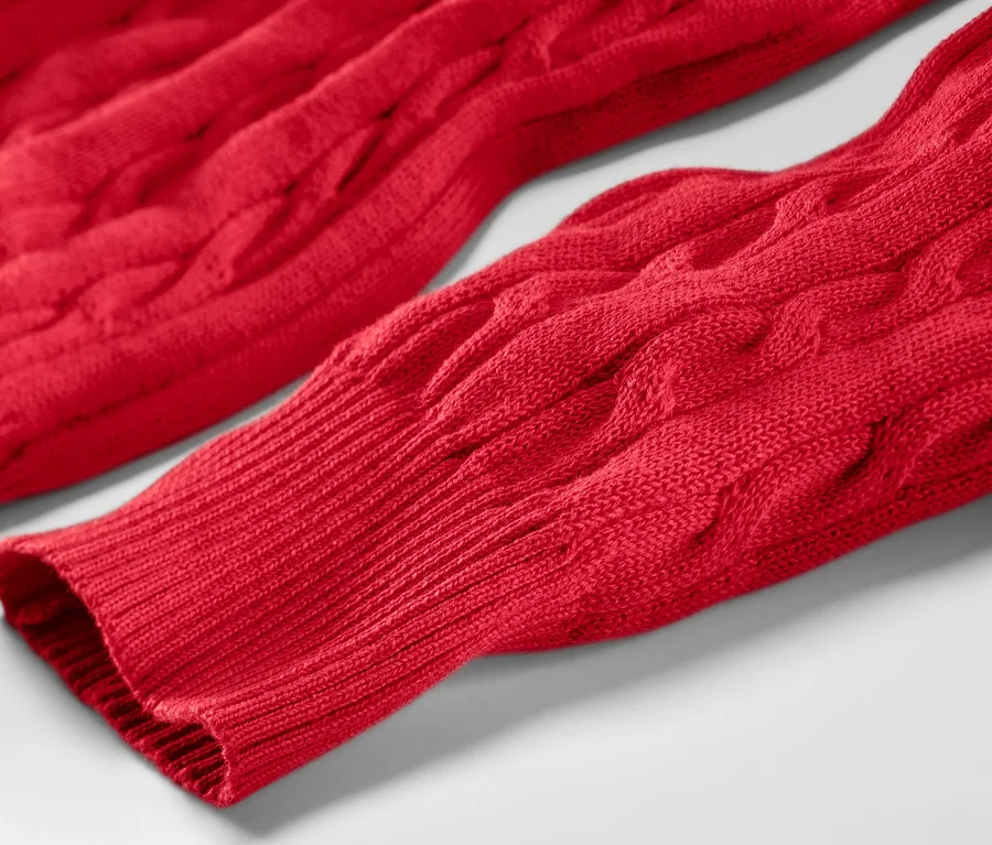 Detailansicht eines roten Zopfstrickpullovers.