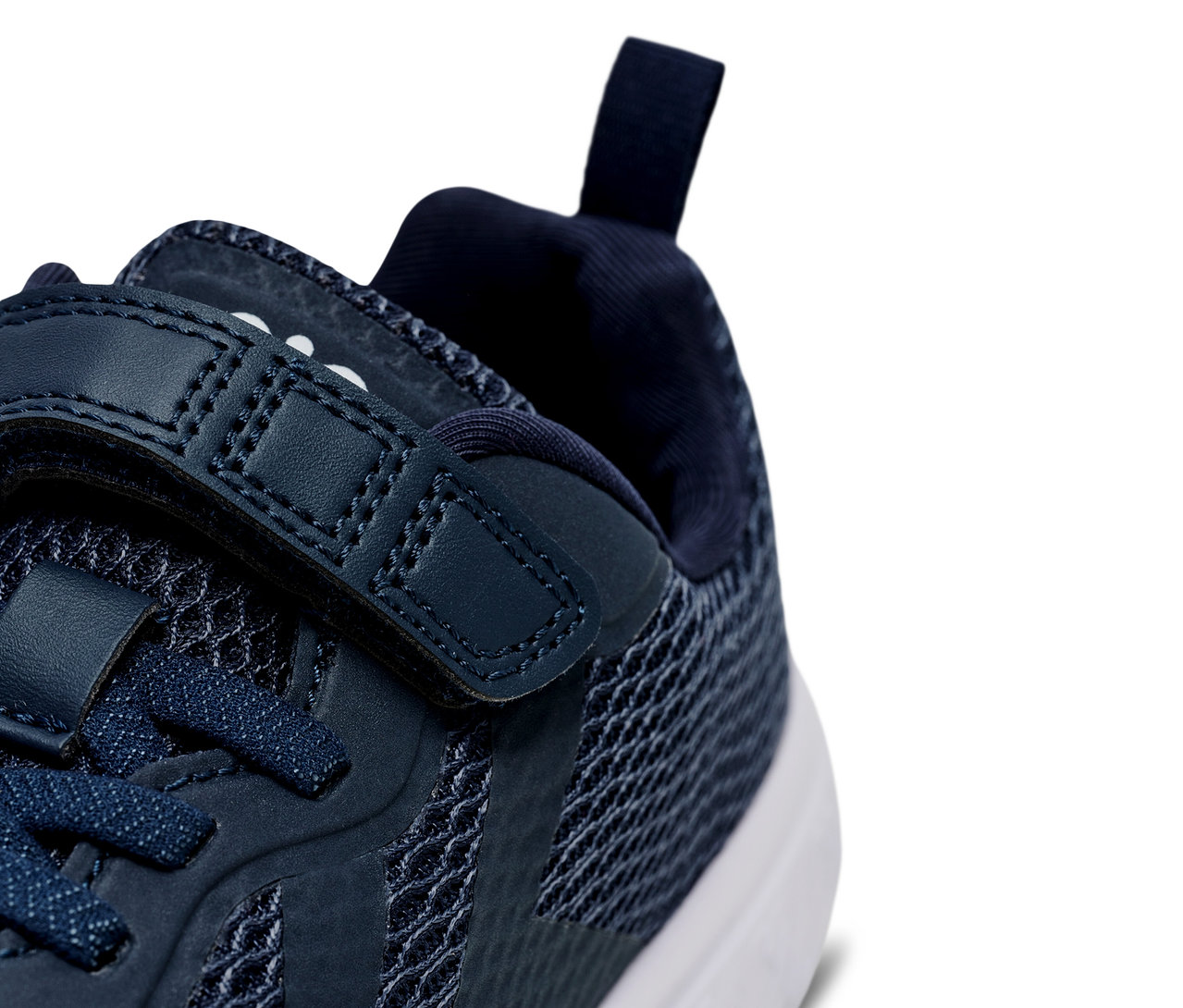 Detailaufnahme eines marineblauen Hummel Actus Recycled Jr Schuhs mit Schnürsenkeln und Klettverschluss.