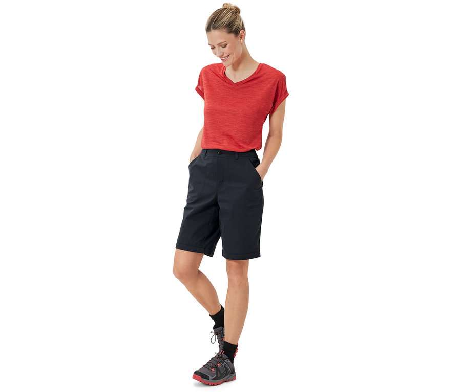 Frau steht mit Händen in den Taschen der schwarzen 2-in-1-Funktionshose.