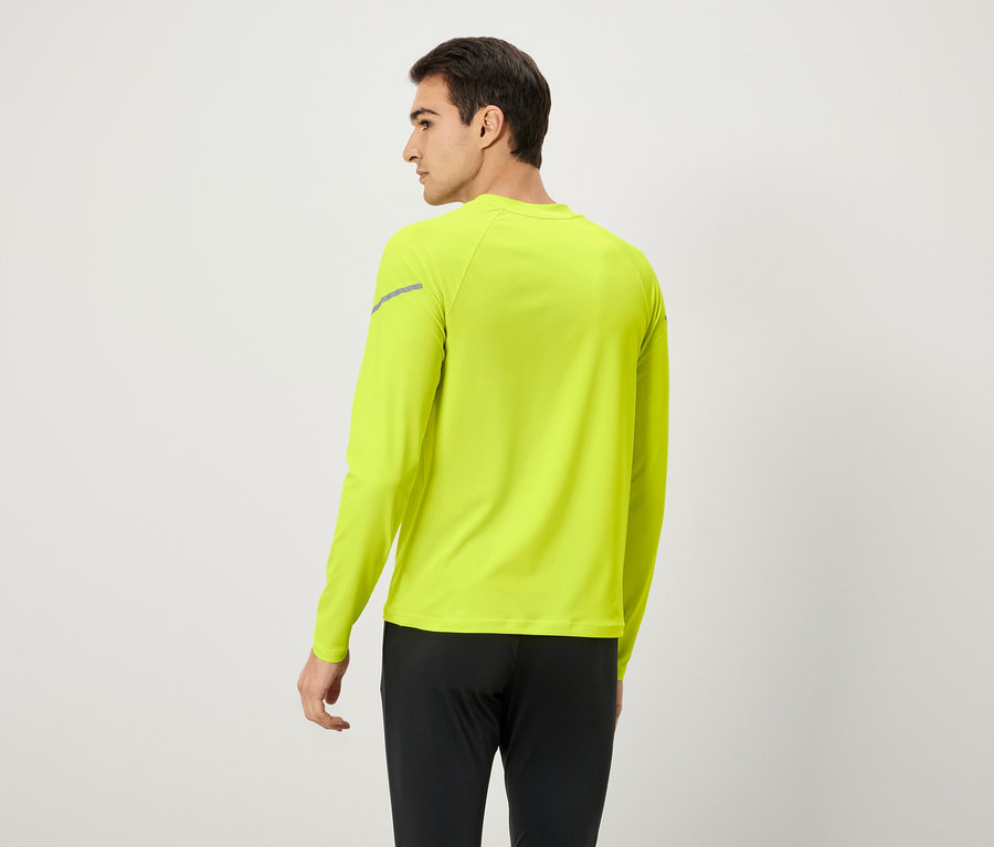 Mann von hinten, trägt ein neongelbes Langarmshirt und eine schwarze Hose.