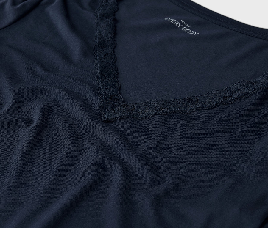 Nahaufnahme eines marineblauen T-Shirts mit V-Ausschnitt und Spitzenbesatz.