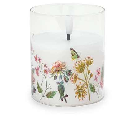 Dekorative Kerze in einem Glasbehälter mit Blumenmuster.