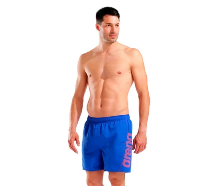 Mann mit freiem Oberkörper und blauen Badehosen der Marke Arena.
