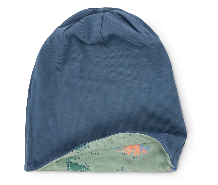 Blaues, gewendetes Mützchen mit Dinosaurier-Muster auf der Innenseite.
