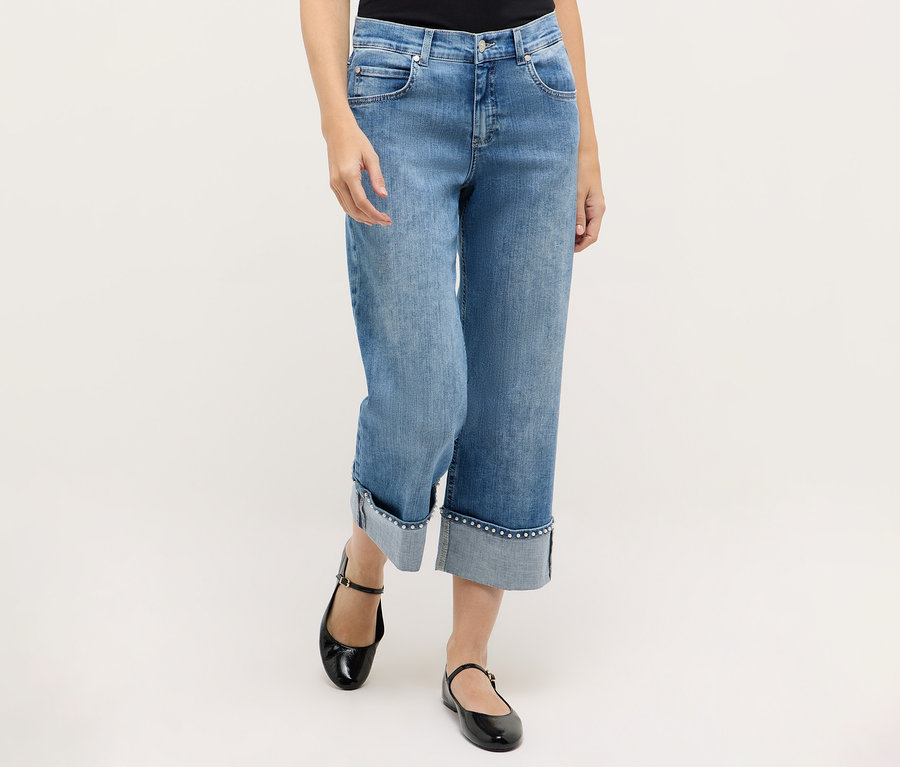 Eine Frau trägt blaue Angels Denim »Linn Cool« Jeans und schwarze Mary Jane Schuhe.