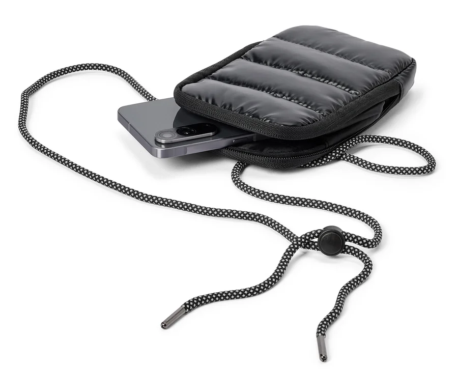 Ein graues Smartphone steckt in einer schwarzen, gesteppten Handytasche mit schwarz-weiß gemusterter Kordel.
