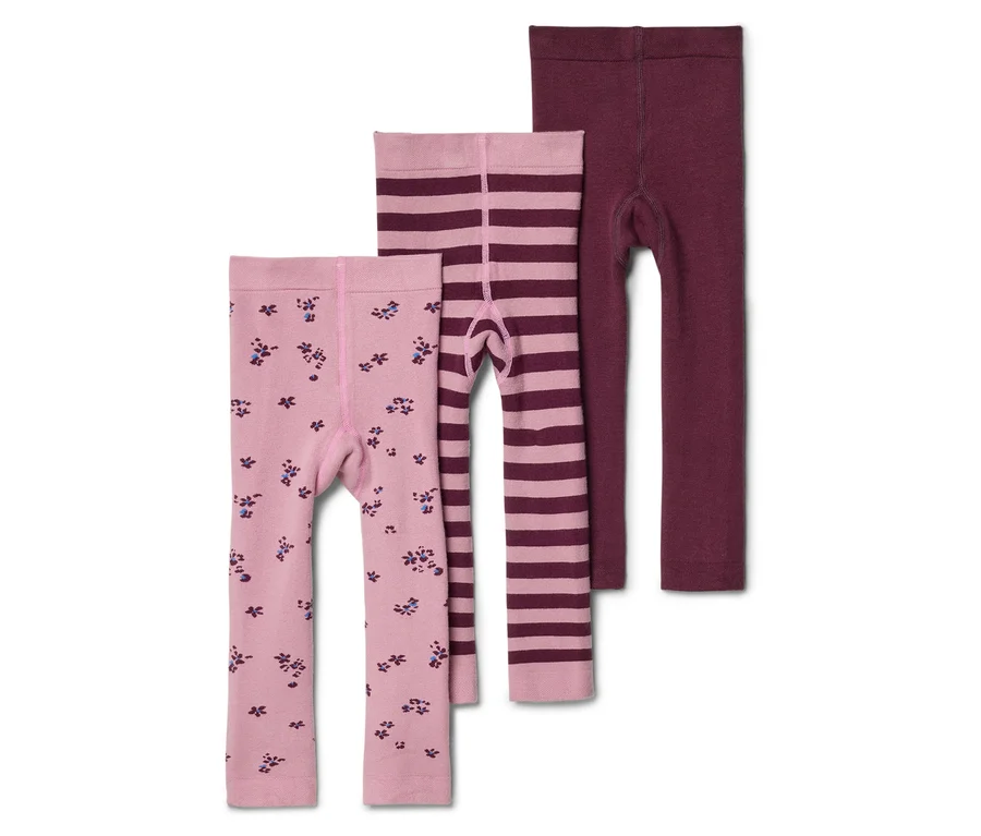 Drei Kinderleggings liegen übereinander: eine hellrosa mit Blumenmuster, eine hellrosa gestreift und eine bordeauxrote.