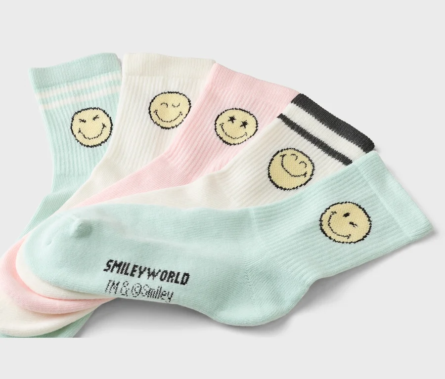 Fünf Socken in Pastellfarben mit Smiley-Motiven liegen übereinander. Die Socken sind hellblau, weiß und rosa.