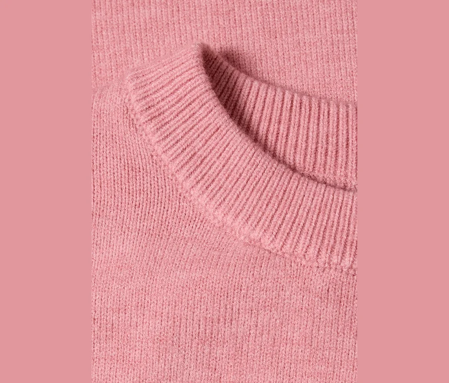 Nahaufnahme eines rosa Street One 3/4-Strickpullovers, der den gerippten Kragen und die Stricktextur zeigt.