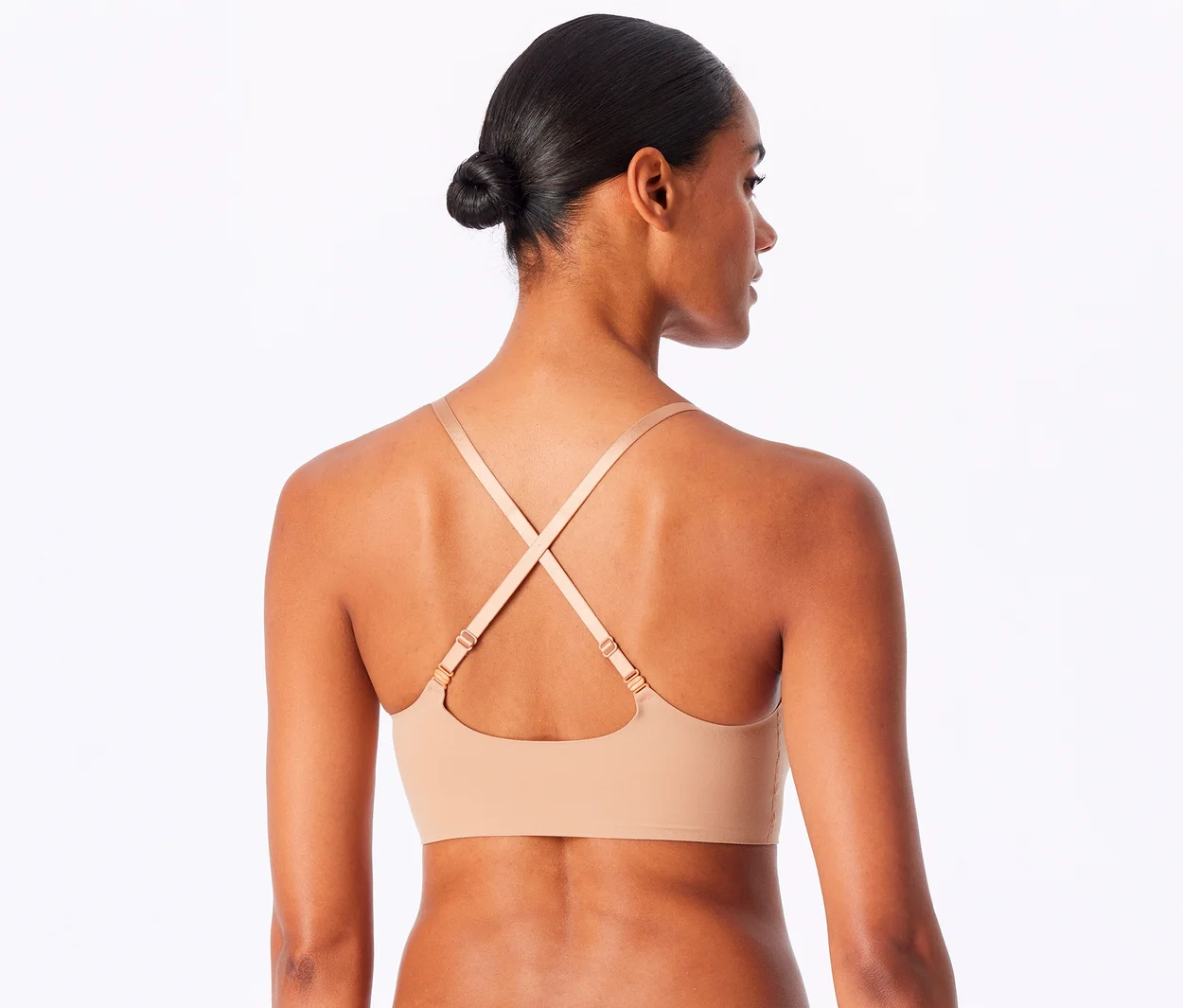 Eine Frau von hinten, leicht zur Seite gedreht, trägt einen SCHIESSER Invisible Bustier mit Pads in Maple mit gekreuzten Trägern.