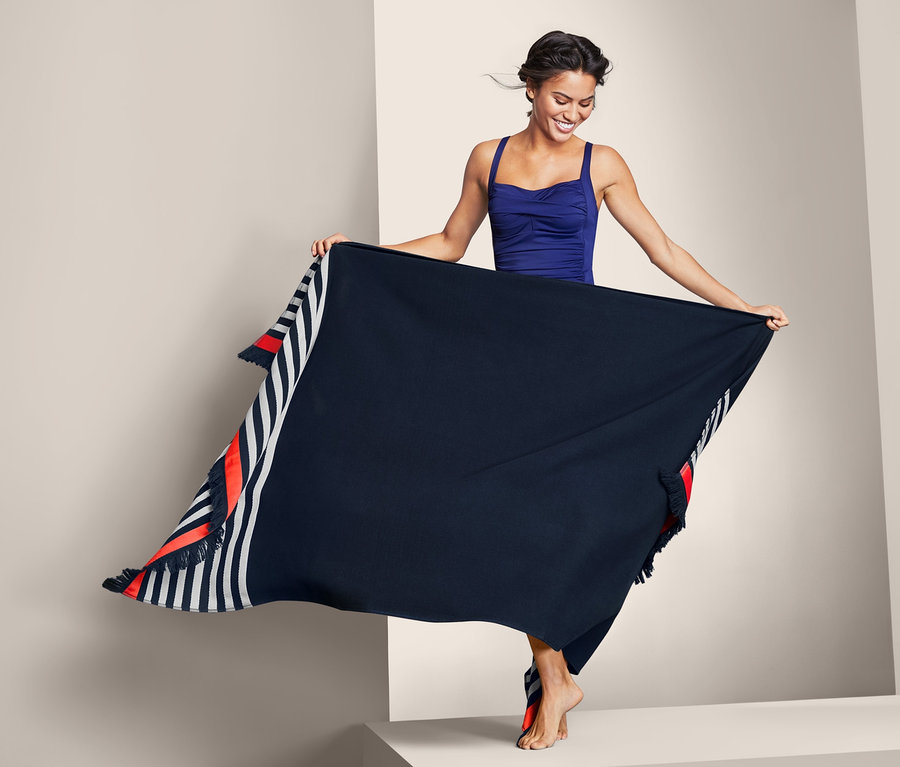 Frau hält XL-Badetuch hoch.