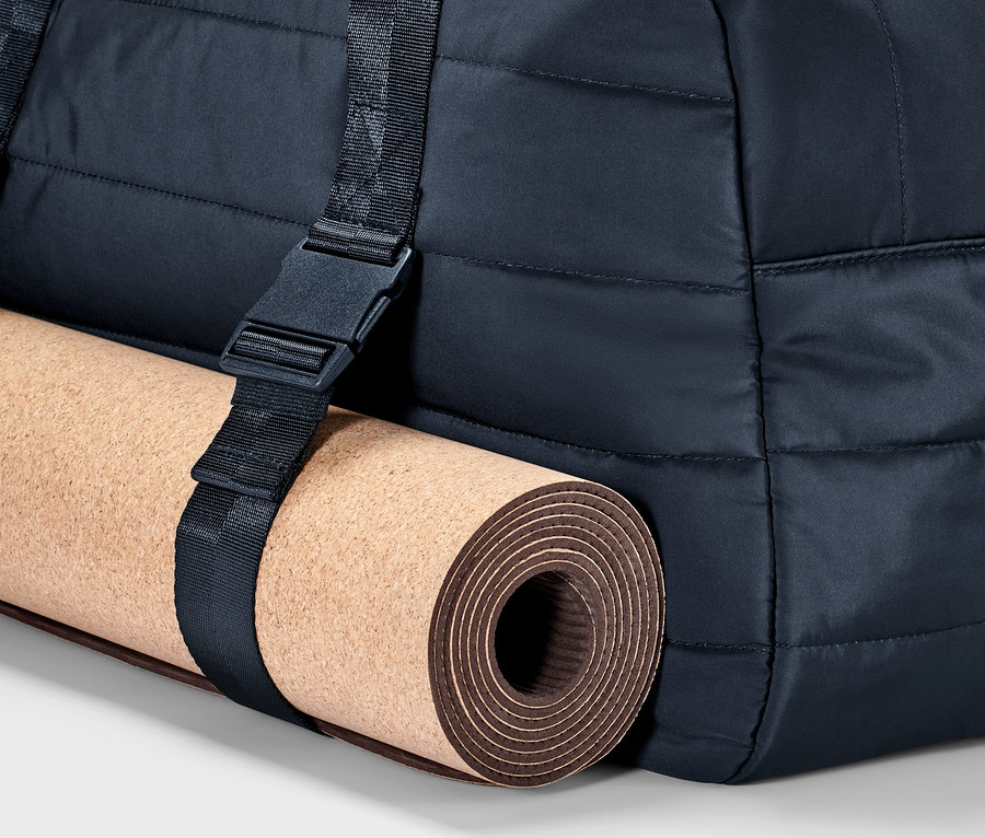 Teil einer Sporttasche mit Yogamatte, die mit einem Gurt befestigt ist.