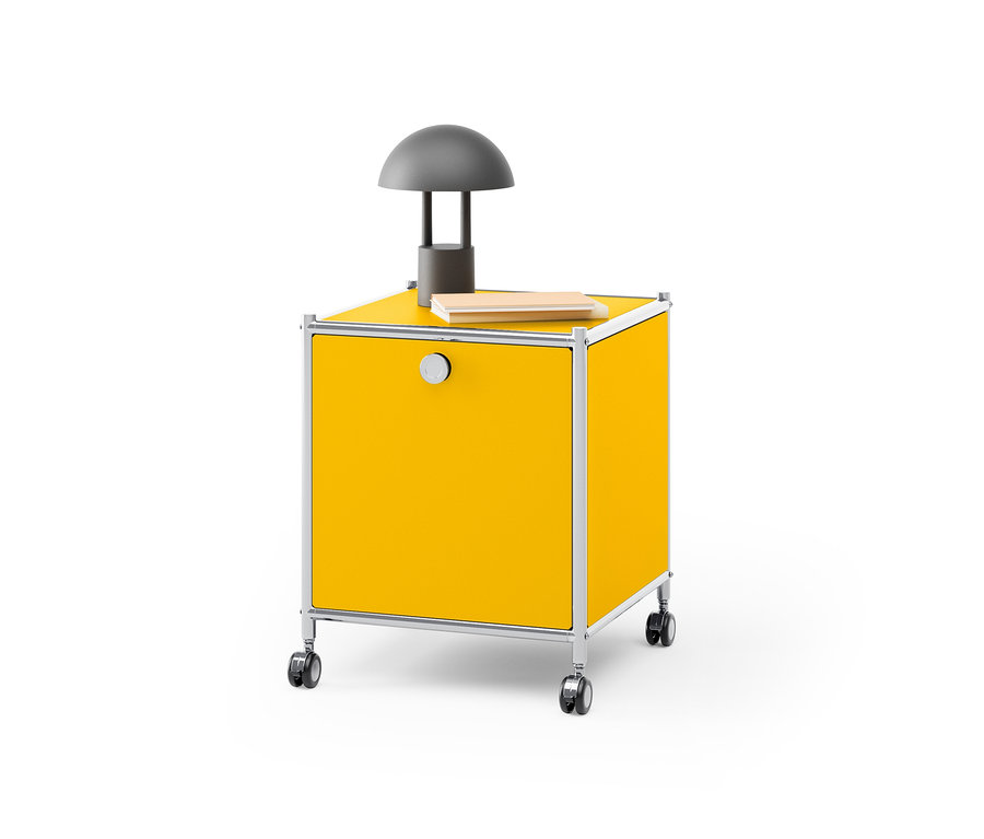 Gelber Beistelltisch Metall »CN3« mit Klappenfach, auf dem eine graue Lampe steht und ein Buch liegt.