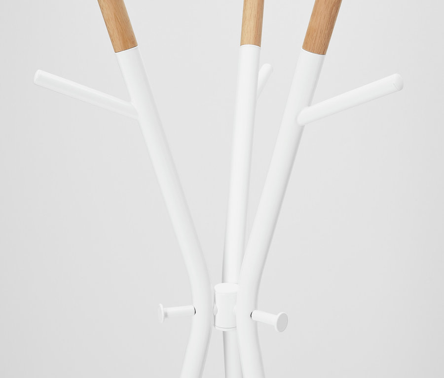 Detailansicht eines weißen Garderobenständers mit Holzdetails.