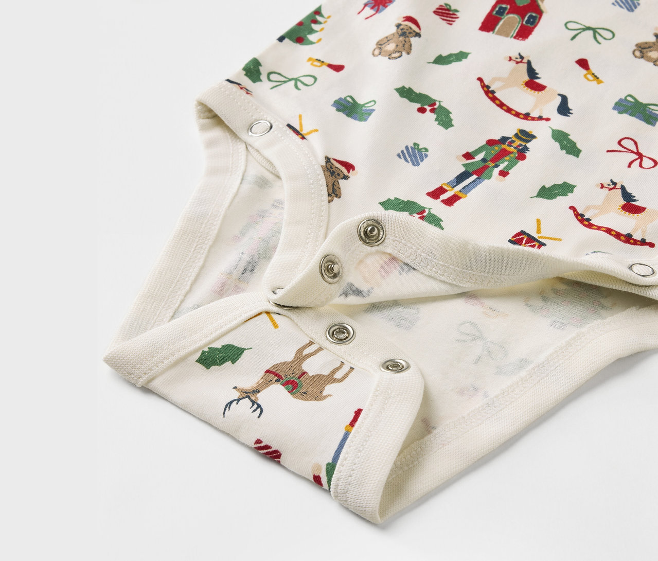 Detail eines Babybodys mit Weihnachtsmotiven.