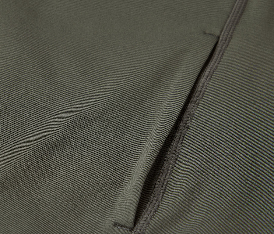 Detailaufnahme eines olivgrünen Stoffes mit einer Reißverschlusstasche.