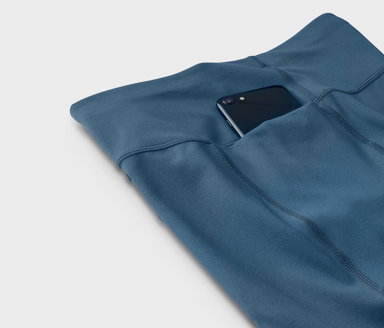 Blaue Leggings mit einem Telefon in der Tasche.