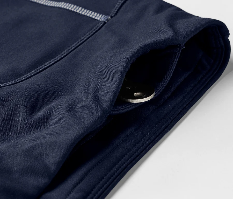 Detailaufnahme einer dunkelblauen Sporthose mit einer Tasche, in der ein Schlüssel liegt.