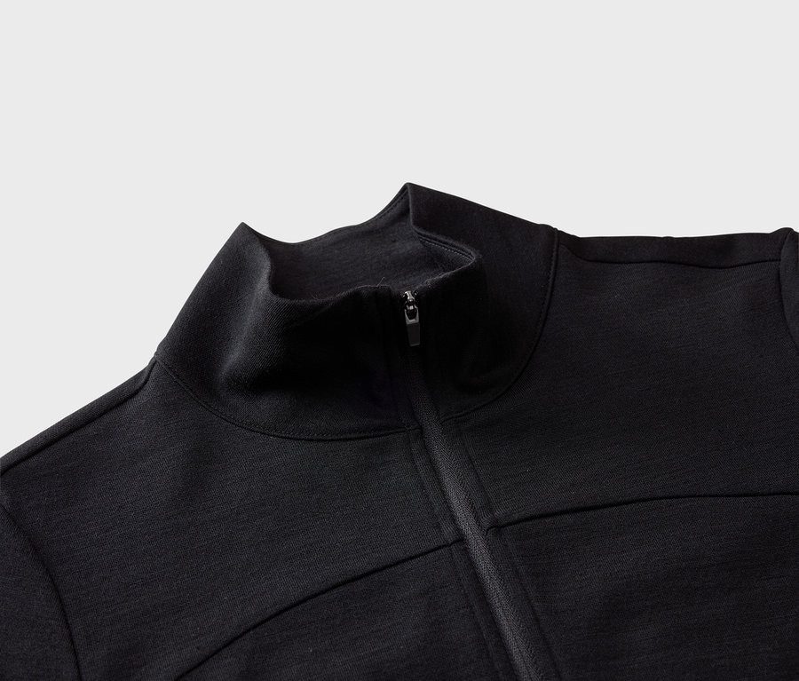 Nahaufnahme einer schwarzen Jacke mit Reißverschluss und hohem Kragen.