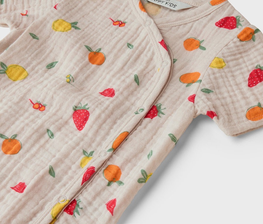 Nahaufnahme eines hellrosa Baby-Stramplers mit Obstmuster.