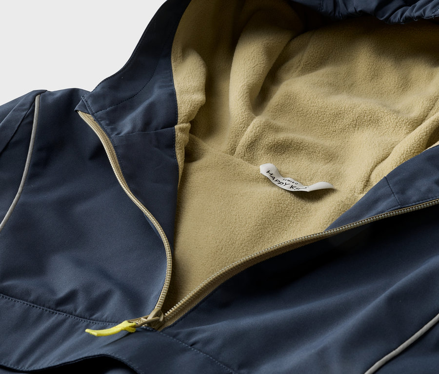 Nahaufnahme einer marineblauen Kapuzenjacke mit gelbem Reißverschluss und beigem Fleecefutter.
