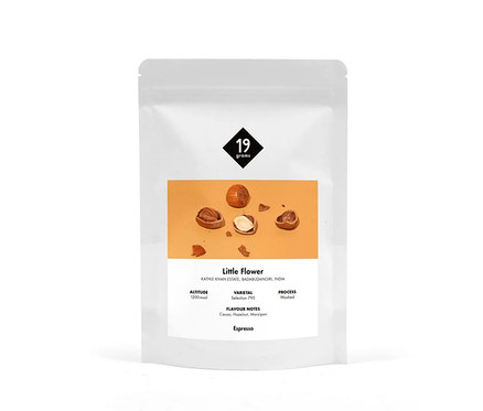 Weiße Verpackung von 19grams Little Flower Espresso mit Abbildung von Haselnüssen.