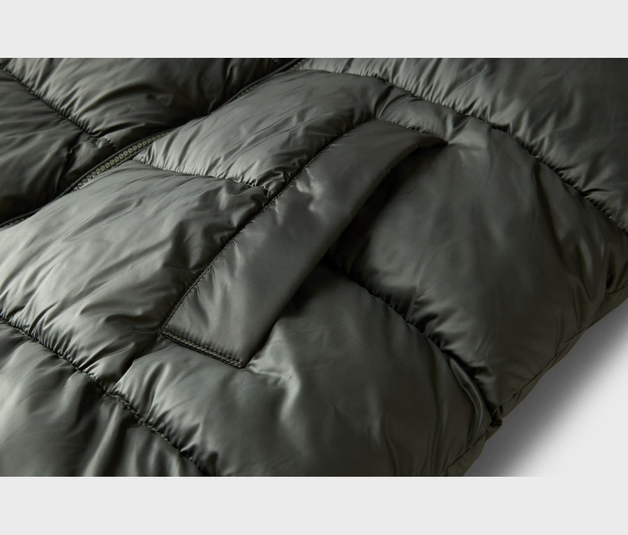 Nahaufnahme einer dunkelgrünen, gesteppten Daunenjacke mit glänzendem Stoff, sichtbaren Nähten und einer seitlichen Tasche.