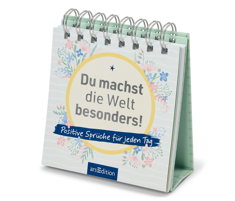 Auf einem Tisch steht ein Tischkalender mit der Aufschrift "Du machst die Welt besonders! Positive Sprüche für jeden Tag".