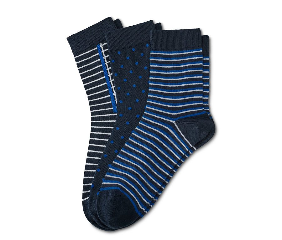 Drei Paar Socken mit verschiedenen Mustern. Ein Paar mit Streifen, ein Paar mit Punkten und ein Paar mit blauen und weißen Streifen.