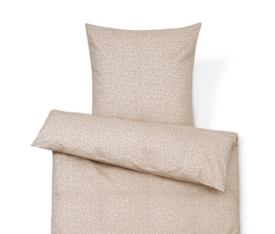 Beige Bettwäsche mit zartem Muster, bestehend aus Kissen, Bettdecke und Dekokissen.