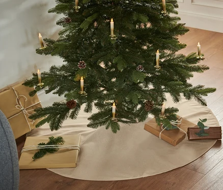 Weihnachtsbaum mit Geschenken und Tannenbaumdecke.