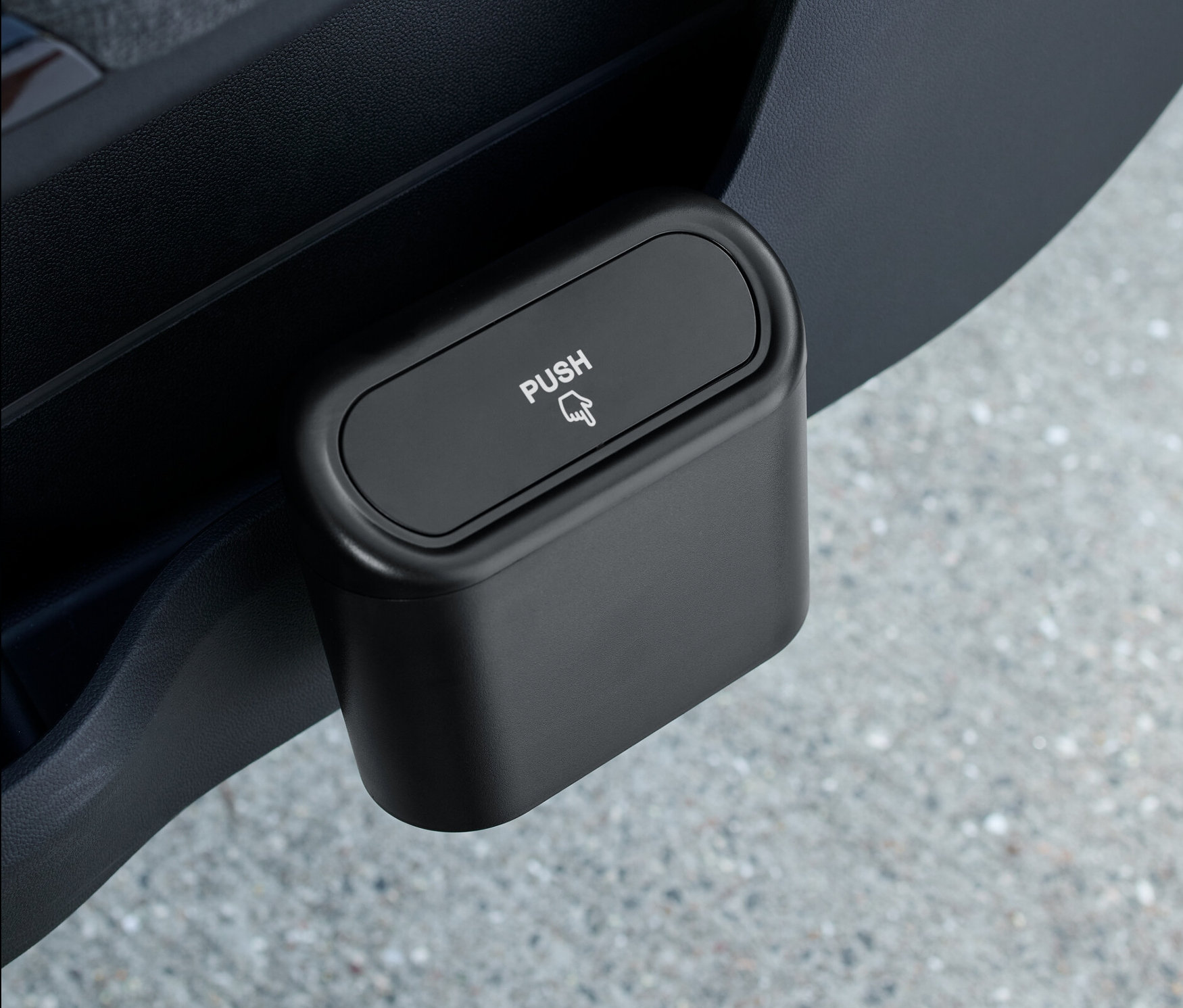 Ein schwarzer Auto-Mülleimer, der in einer Autotür platziert ist.