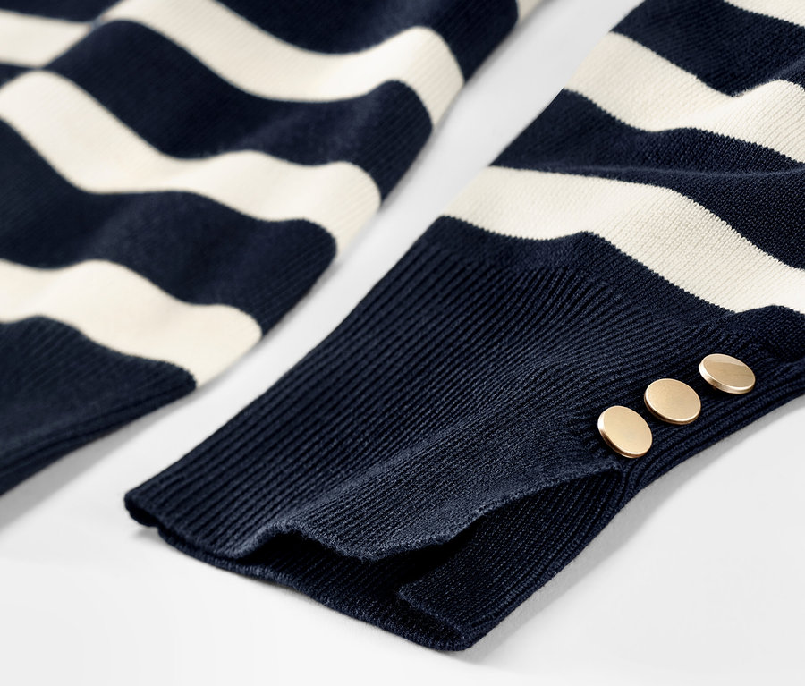 Detailansicht eines gestreiften Feinstrickpullovers in Dunkelblau mit Knöpfen am Ärmel.
