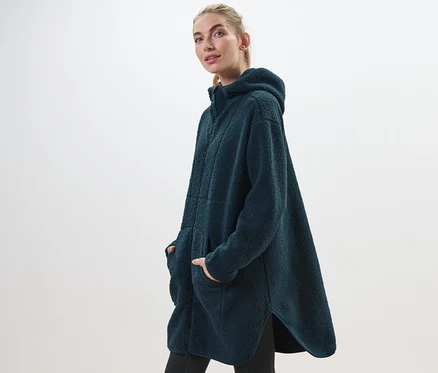 Frau posiert in einem oversized Teddy-Mantel.