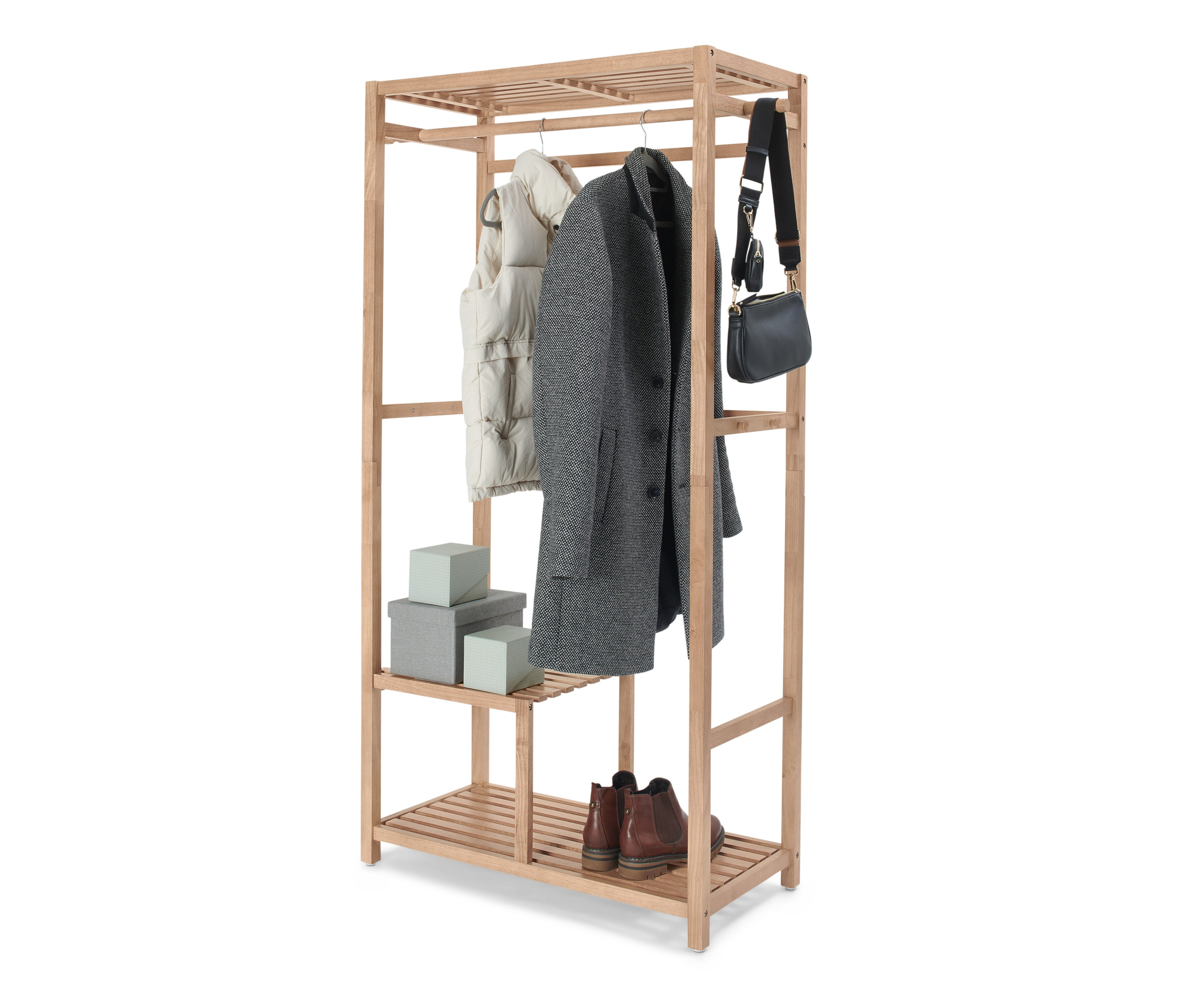 Kleidung hängt an einer Garderobe, Massivholz. Schuhe und Schachteln stehen im unteren Regal.