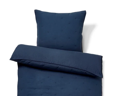 Ein marineblaues Bettwäsche-Set mit Steppmuster.