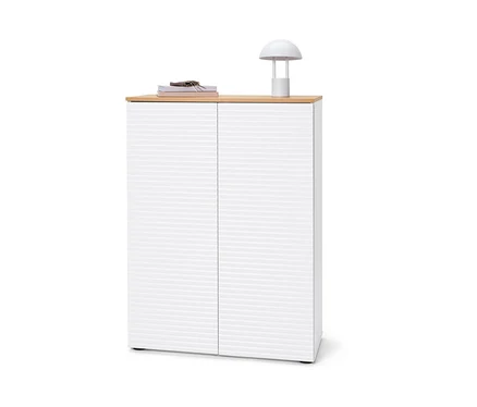 Schuhschrank mit Büchern, Schlüsseln und Lampe oben drauf.