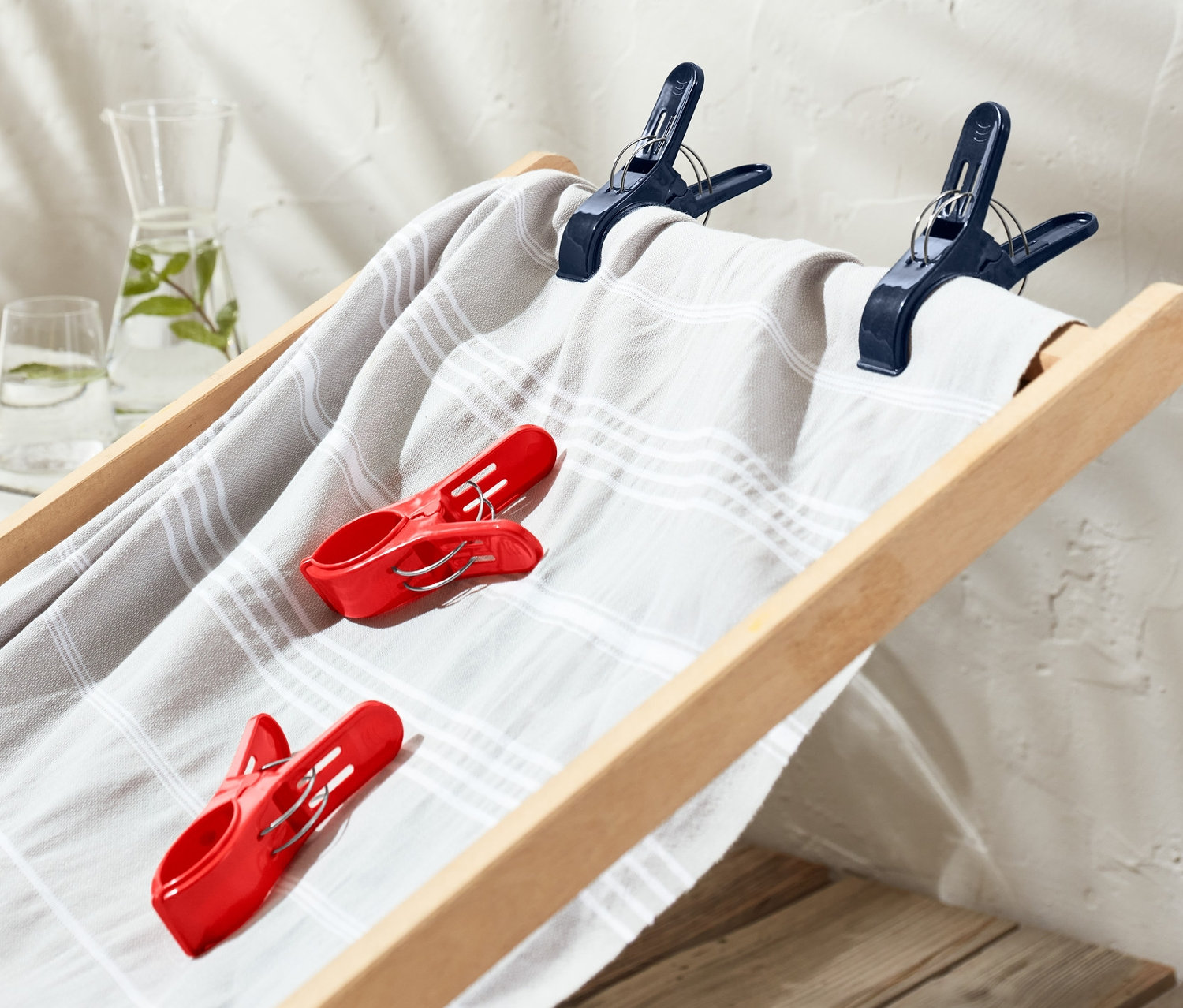 Auf einer Liege sind 4 Handtuchclips befestigt.