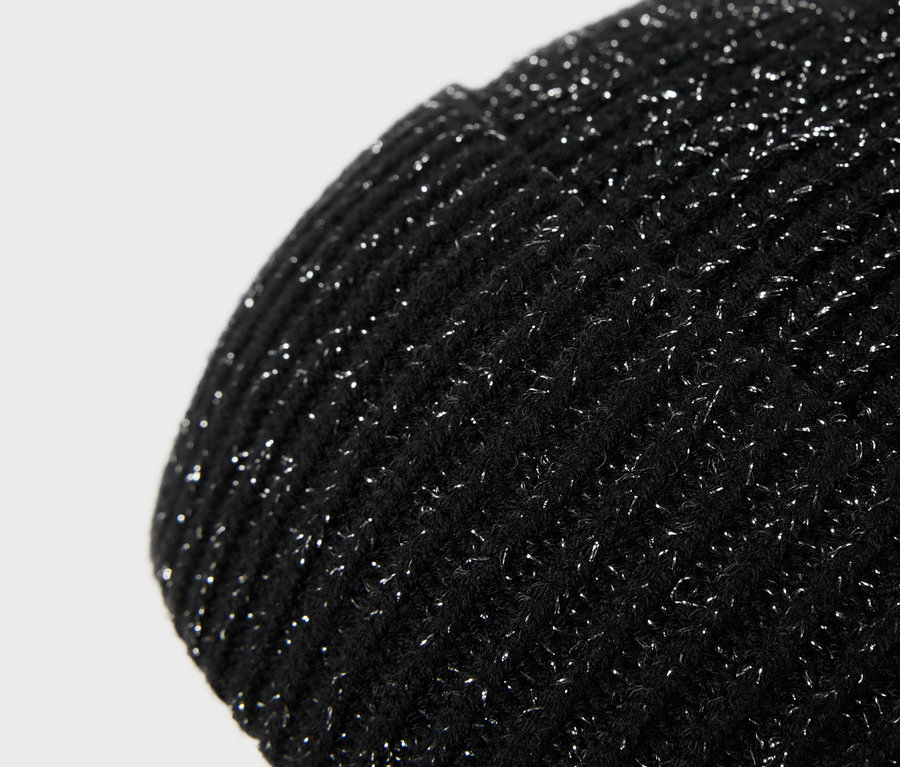 Detailansicht einer schwarzen Strickmütze mit glitzernden Silberfäden.