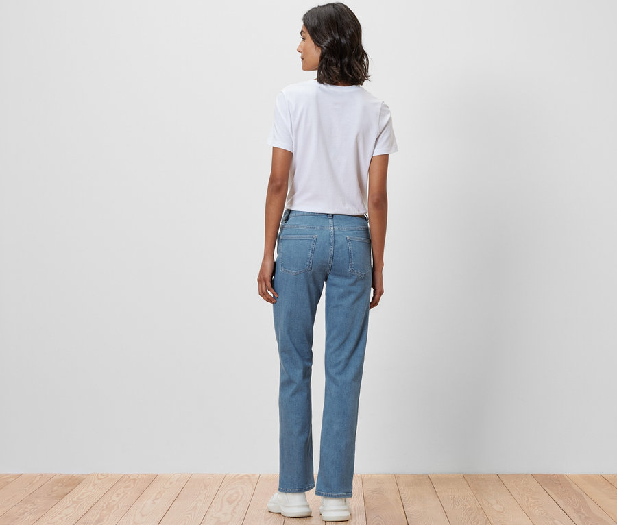 Eine Frau steht mit dem Rücken zur Kamera und trägt eine Straight Jeans ‒ Fit »Kira« und ein weißes T-Shirt.