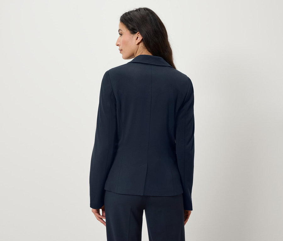Frau von hinten in marineblauem Blazer und Hose.