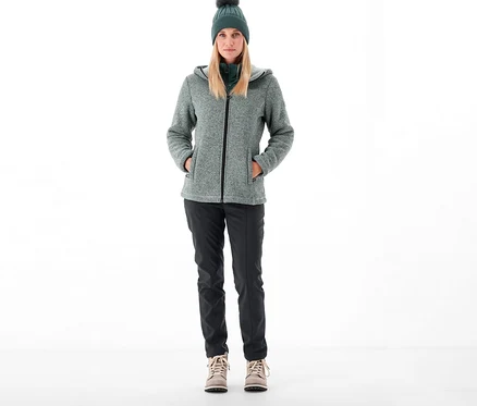 Frau steht und trägt CMP Damen-Softshellhose, Jacke und Mütze.