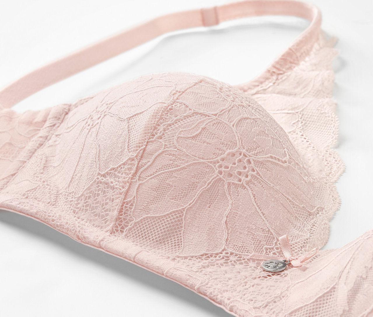 Detailaufnahme eines roséfarbenen Softschalen-BHs mit Spitze.