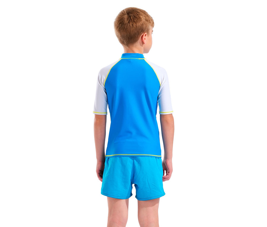 Rückansicht eines Kindes mit blonden Haaren, das ein blau-weißes Rashguard-Shirt und blaue Badeshorts trägt.